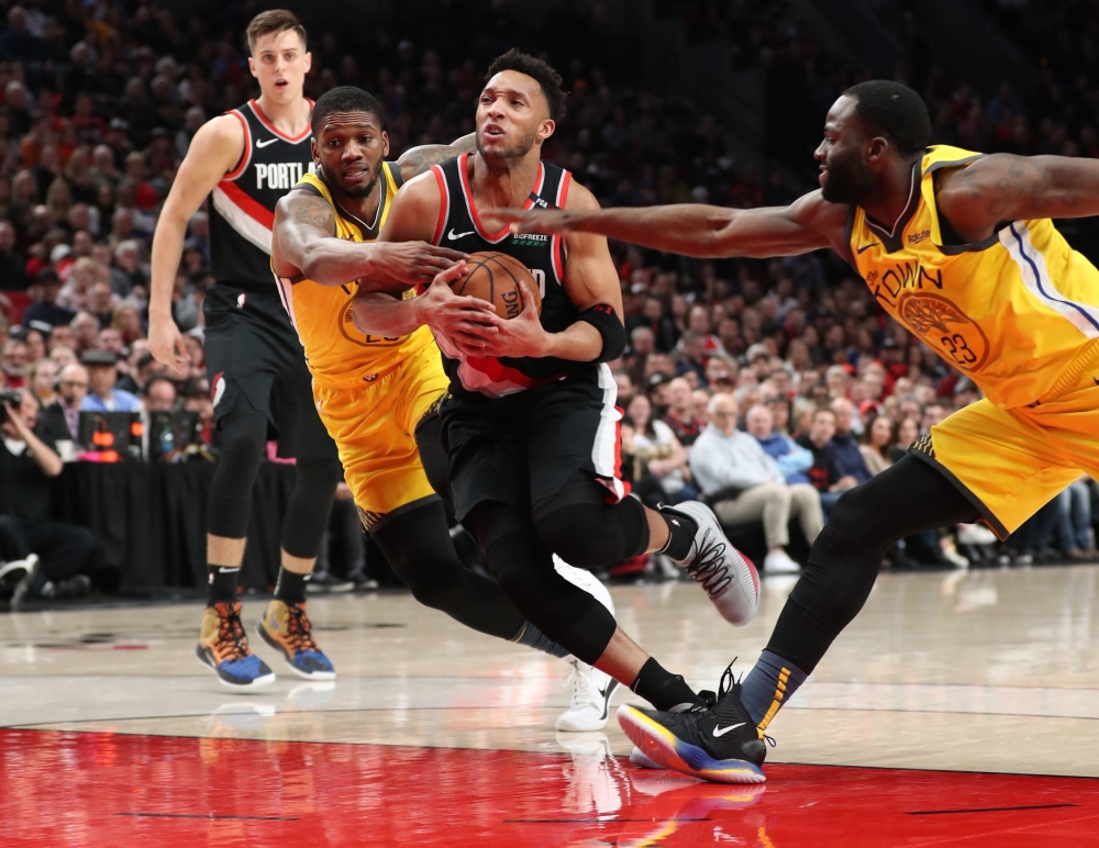 Portland Trail Blazers guard Evan Turner (1) drives in between Golden State Warriors forward Alfonzo McKinnie (28) and Warriors' forward Draymond Green (23) in the second half at Moda Center. — Reuters