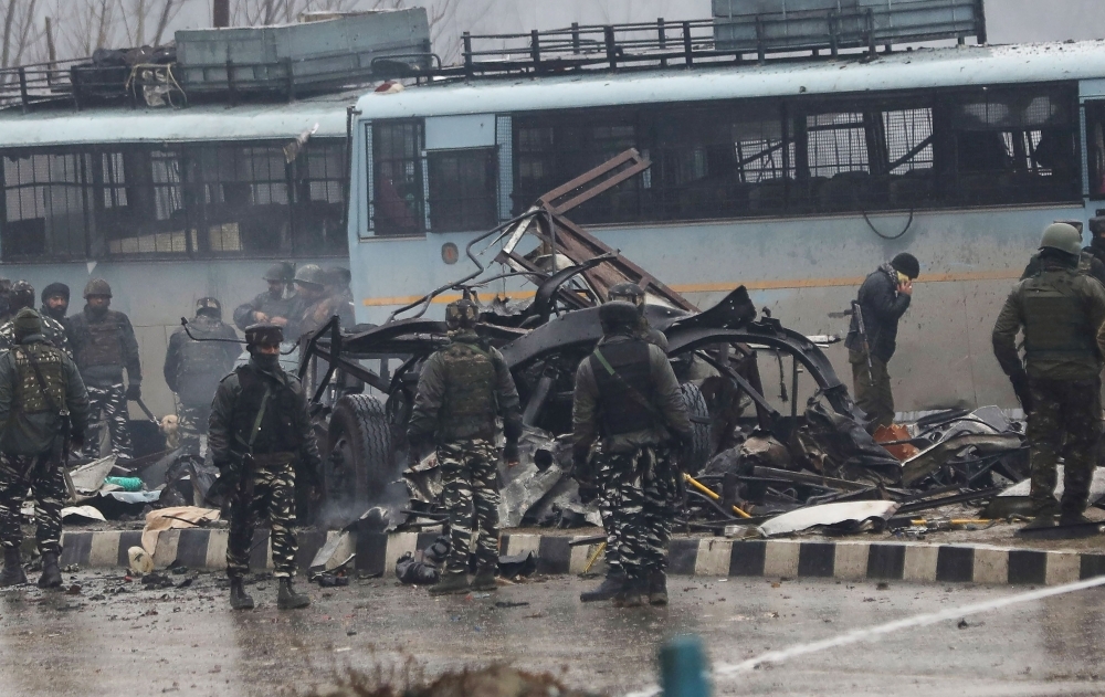 Indian security forces inspect the remains of a vehicle following an attack on a paramilitary Central Reserve Police Force (CRPF) convoy near Awantipur town in the Lethpora area of Kashmir about 30 km south of Srinagar, on Thursday. — AFP