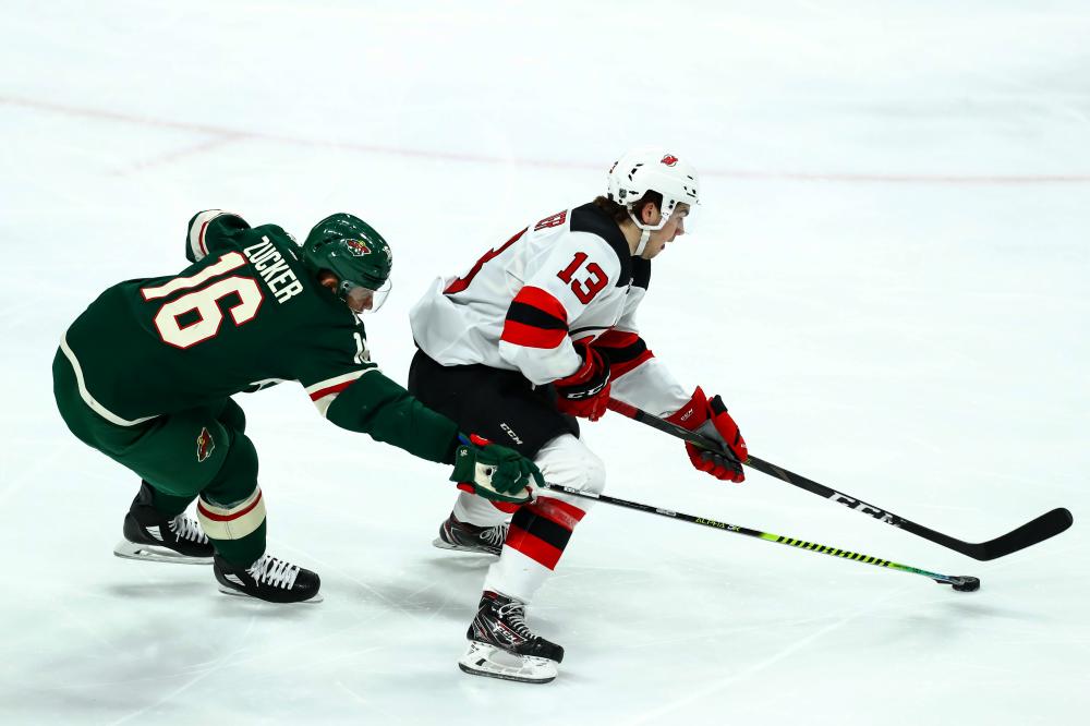 New Jersey Devils’ center Nico Hischier (R) skates with the puck against Minnesota Wild’s left wing Jason Zucker during their NHL game at Xcel Energy Center in Saint Paul Friday. — Reuters