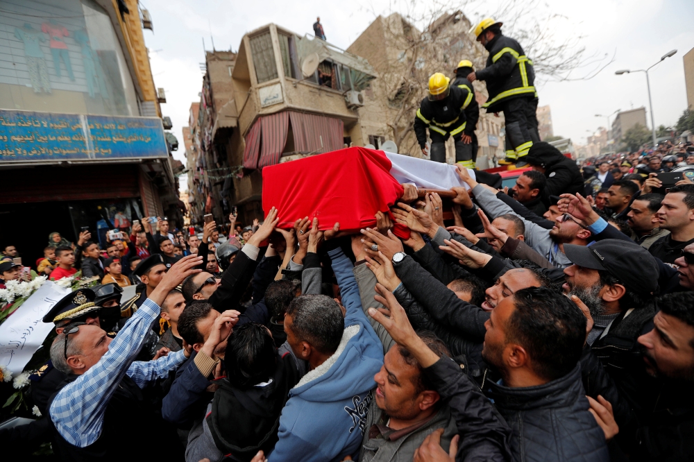 


Mourners carry a coffin containing the body of  police officer Mahmoud Abou El Yazied who was killed in a blast in Cairo on Monday evening. — AFP