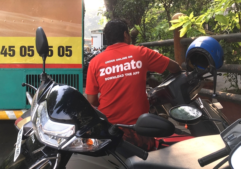 An Indian delivery man working with the food delivery app Zomato sits on his bike in a business district in Mumbai in this Dec. 24, 2018 file photo. — AFP