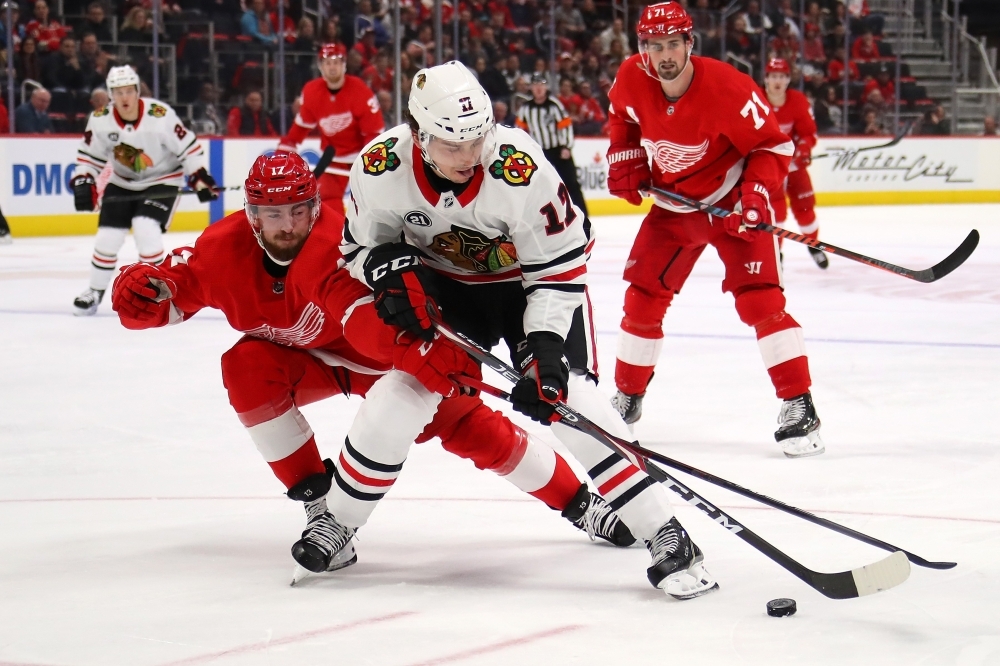 Dylan Strome No. 17 of the Chicago Blackhawks battles for the puck with Filip Hronek No. 17 of the Detroit Red Wings during the third period at Little Caesars Arena on Wednesday in Detroit, Michigan. Chicago won the game 5-4 in overtime. — AFP