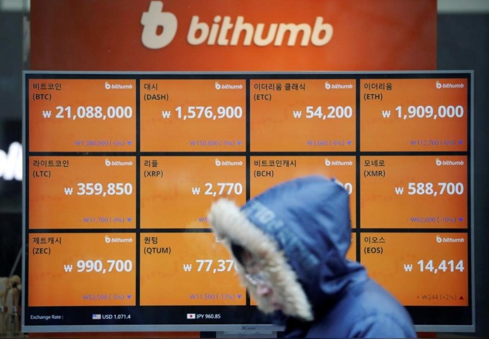 A man walks past an electric board showing exchange rates of various cryptocurrencies at Bithumb cryptocurrencies exchange in Seoul, South Korea, in this file photo. — Reuters