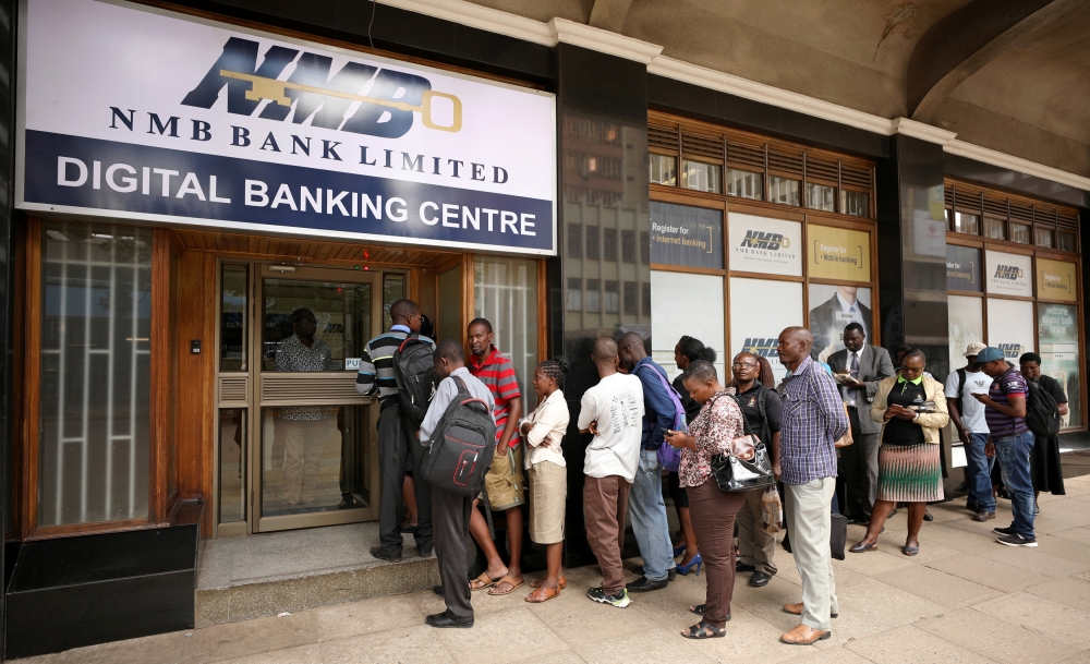 People queue outside a bank in Harare, Zimbabwe on Friday. — Reuters
