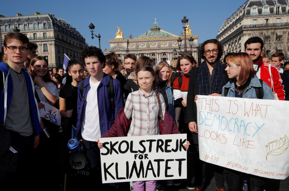 16-year-old Swedish environmental activist Greta Thunberg, holding a banner, and Anuna De Wever, a Belgian climate student activist, take part in a protest claiming for urgent measures to combat climate change, in Paris, France, on Friday. — Reuters