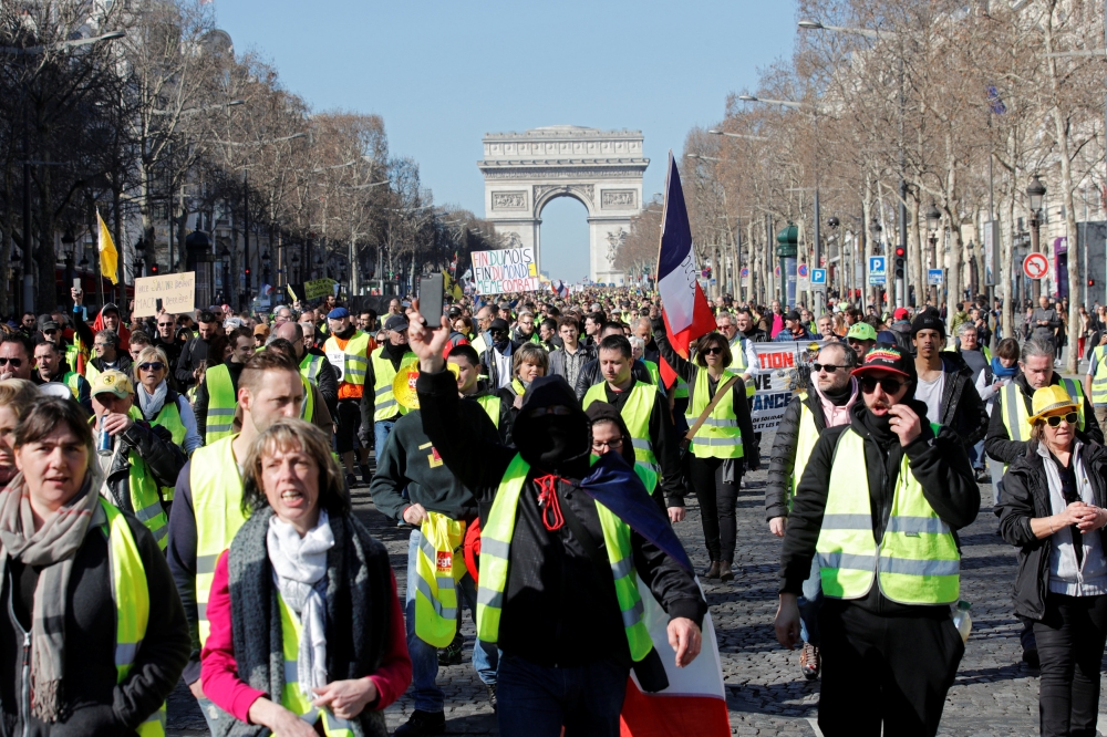 Protesters wearing yellow vests march down the Champs Elysees from the Arc de Triomphe during a demonstration in Paris, Saturday. — Reuters