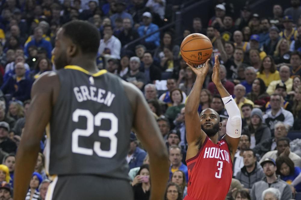 Houston Rockets’ guard Chris Paul shoots against Golden State Warriors during their NBA game at Oracle Arena in Oakland Saturday. — Reuters
