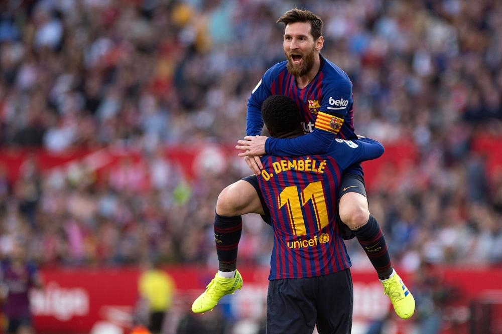 Barcelona’s forward Lionel Messi celebrates with teammate Ousmane Dembele after scoring a goal during the Spanish league football match against Sevilla at the Ramon Sanchez Pizjuan Stadium in Sevilla Saturday. — AFP 