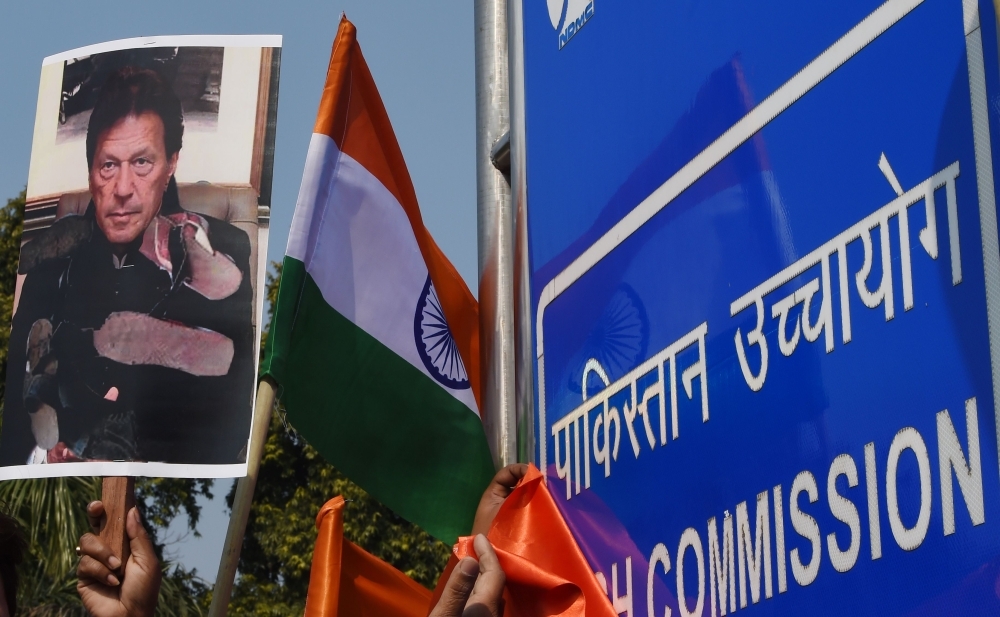 Supporters of Bharatiya Janata Party (BJP) hold Indian National flags and a placard with a picture of Pakistan Prime Minister Imran Khan during a protest outside the embassy of Pakistan, in New Delhi, on Thursday. — AFP