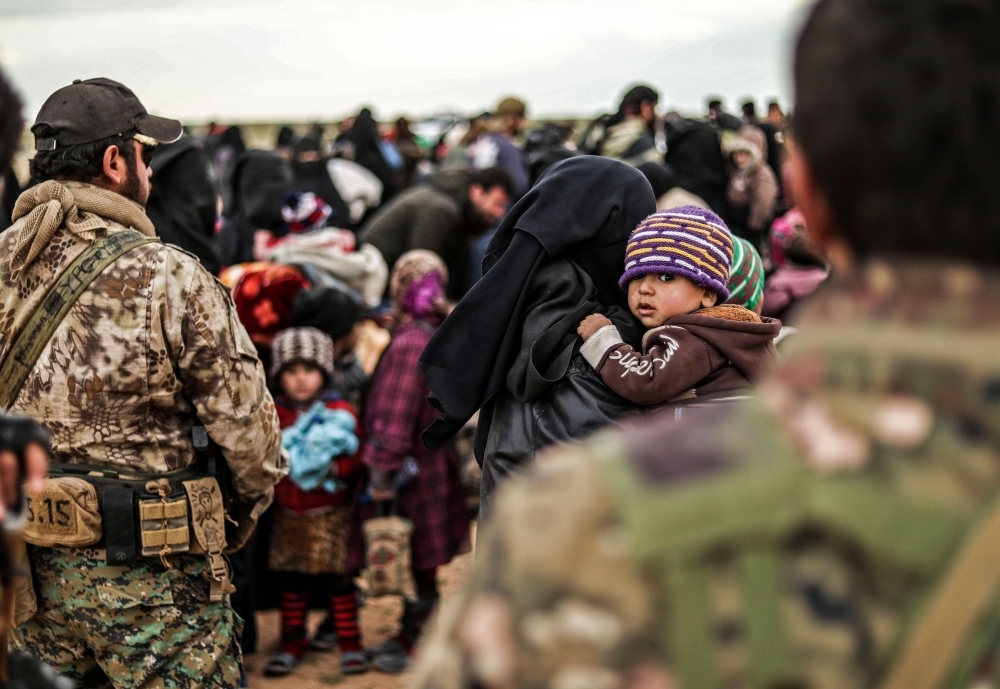 Civilians evacuated from Daesh’s embattled holdout of Baghouz wait at a screening area held by the US-backed Kurdish-led Syrian Democratic Forces (SDF), in the eastern Syrian province of Deir El-Zor, on Thursday. — AFP