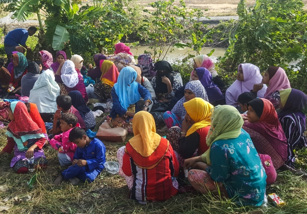 Rohingya refugees, who landed on an isolated northern shore near the Malaysia-Thai border, huddle in a group in Kangar on Friday, following their detention by Malaysian immigration authorities. — AFP