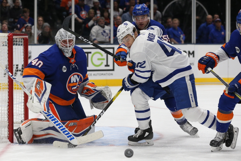 Toronto Maple Leafs left wing Trevor Moore (42) and New York Islanders defenseman Johnny Boychuk (55) play the puck in front of New York Islanders goalie Robin Lehner (40) during the third period at the Nassau Veterans Memorial Coliseum. — Reuters