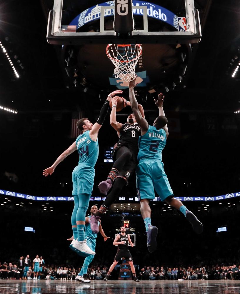 Charlotte Hornets’ forwards Frank Kaminsky (44) and Marvin Williams (2) defend against Brooklyn Nets’ guard Spencer Dinwiddie during their NBA game at Barclays Center in Brooklyn Friday. — Reuters 