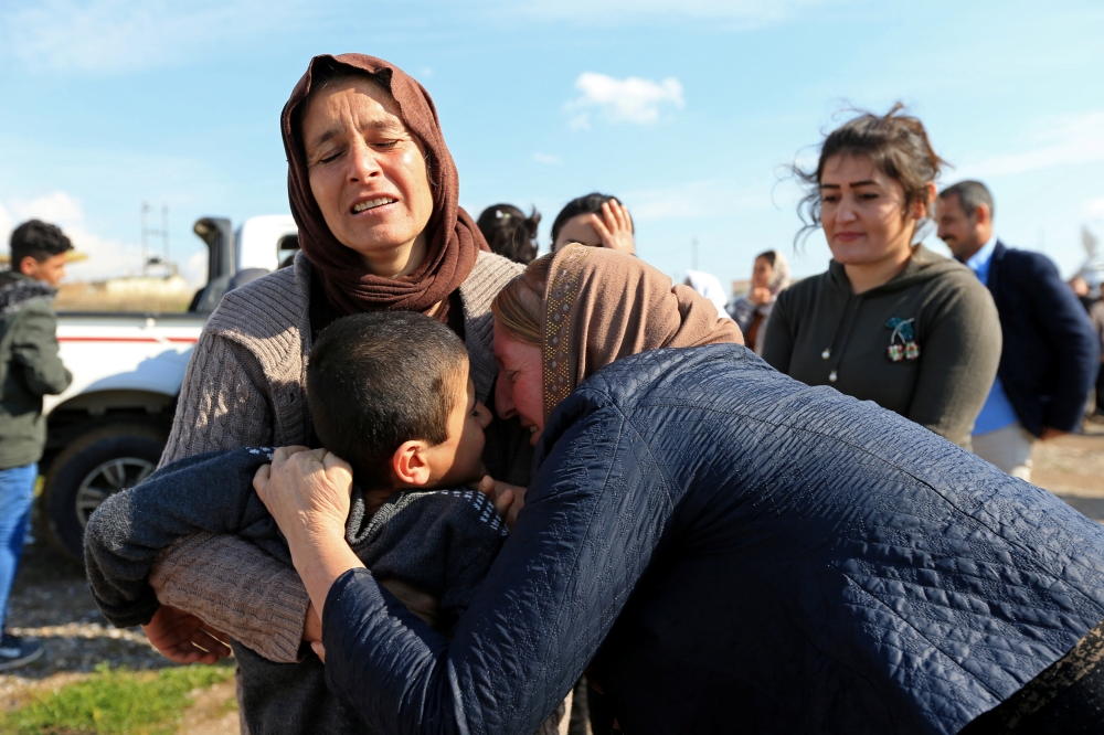 Relatives hug a Yazidi survivor boy following his release from Daesh (so-called IS) militants in Syria, in the Iraqi city of Duhok, on Saturday. — Reuters