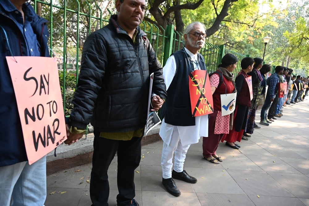 Indian protesters hold hands to form a human chain during an anti-war demonstration called by pacifist organizations in New Delhi on Monday. — AFP
