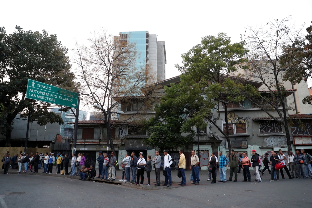People wait for transportation during a blackout in Caracas, Venezuela, on Friday. — Reuters
