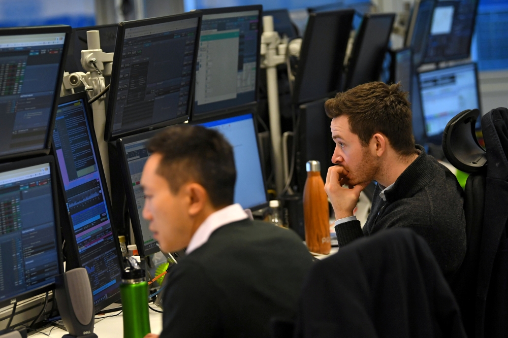 Dealers work at their desks whilst screens show market data following a vote on Prime Minister Theresa May’s Brexit plan B at CMC Markets in London, Britain, in this Jan. 30, 2019 file photo. — Reuters