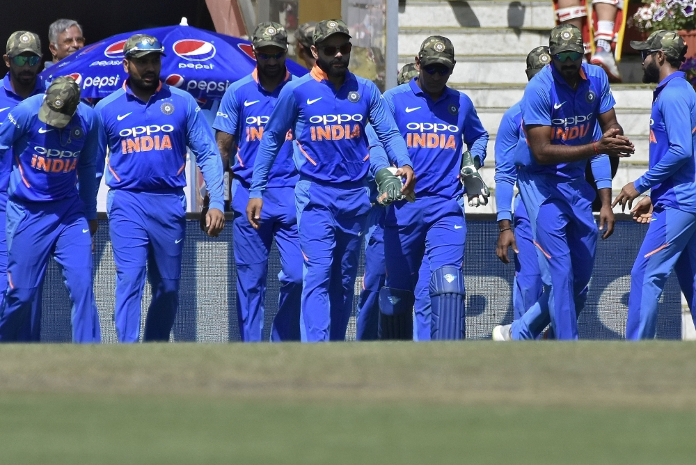 India's captain Virat Kohli (C) and his teammates wearing army camouflage-style caps walk onto the field in the Third One-Day International against Australia at the Jharkhand State Cricket Association Stadium, Ranchi, India, on Friday. — Reuters