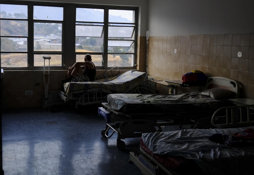 A patient looks out from a window at Miguel Perez Carreno hospital, in Caracas, during the worst power outage in Venezuela’s history, on Sunday. — AFP