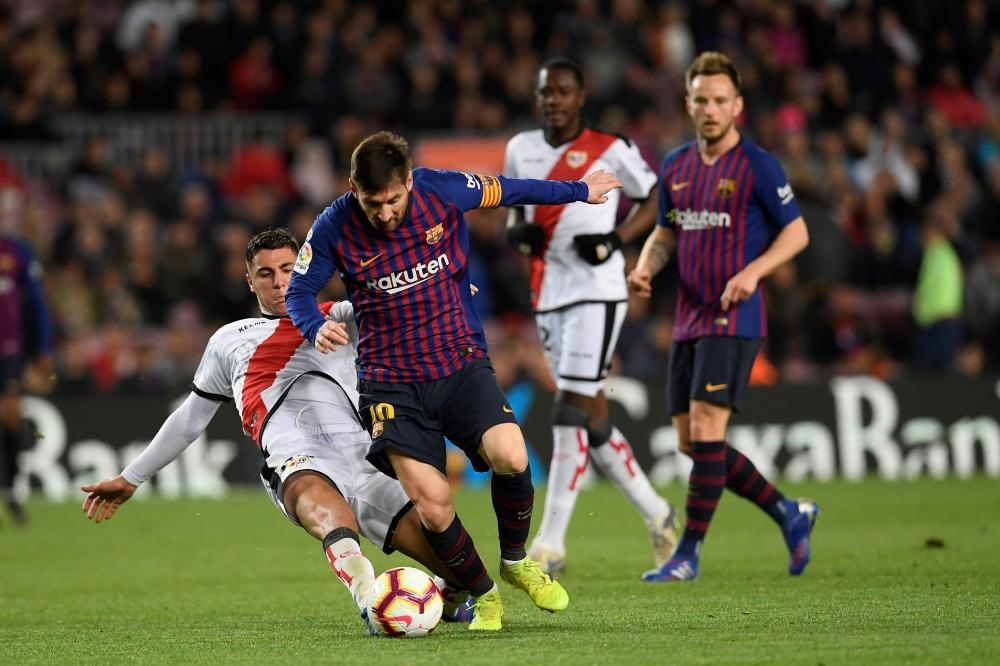 Barcelona’s Lionel Messi (2ns L) vies for the ball with Rayo Vallecano’s midfielder Santi Comesana during the Spanish league football match at the Camp Nou Stadium in Barcelona Saturday. — AFP 