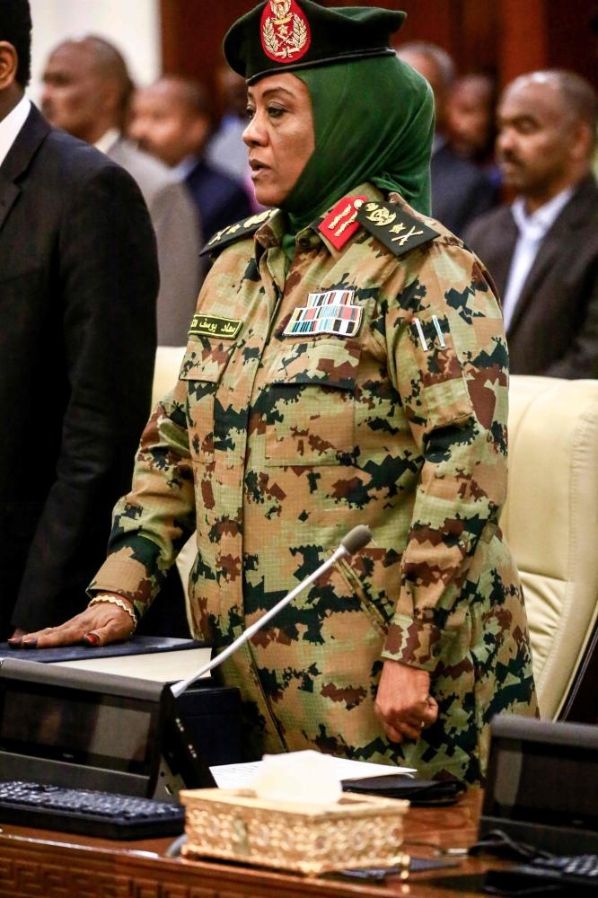 Lt. Gen. Suad Youssef Al-Karb, Sudan's new Minister for Social Security, is sworn in with other members of the newly-formed 20-member Cabinet at the presidential palace in the capital Khartoum, Thursday. President Bashir swore in a new Cabinet to tackle the country's economic crisis that has triggered demonstrations against his rule since December. The new Cabinet led by Prime Minister Mohamed Tahir Eila is the third such government formed in less than two years, with the previous two sacked by Bashir for failing to revive the dilapidated economy. — AFP