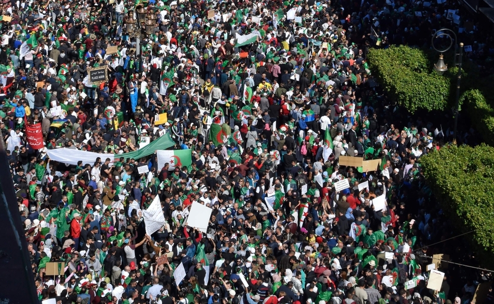 Algerians demonstrate during the first Friday rally since the president’s surprise announcement this week that he would not seek re-election but was canceling April polls, in central Algiers on Monday. — AFP