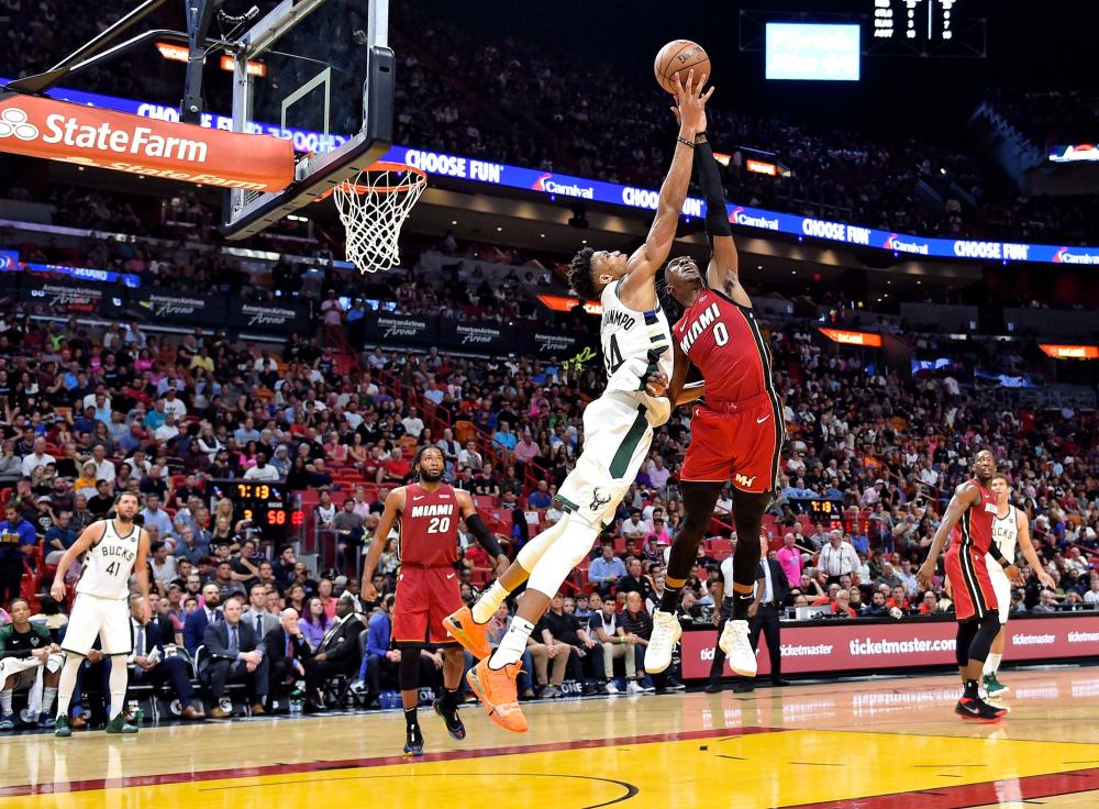 Milwaukee Bucks’ forward Giannis Antetokounmpo (L) and Miami Heat guard Josh Richardson reach for a rebound during their NBA game at American Airlines Arena in Miami Friday. — Reuters