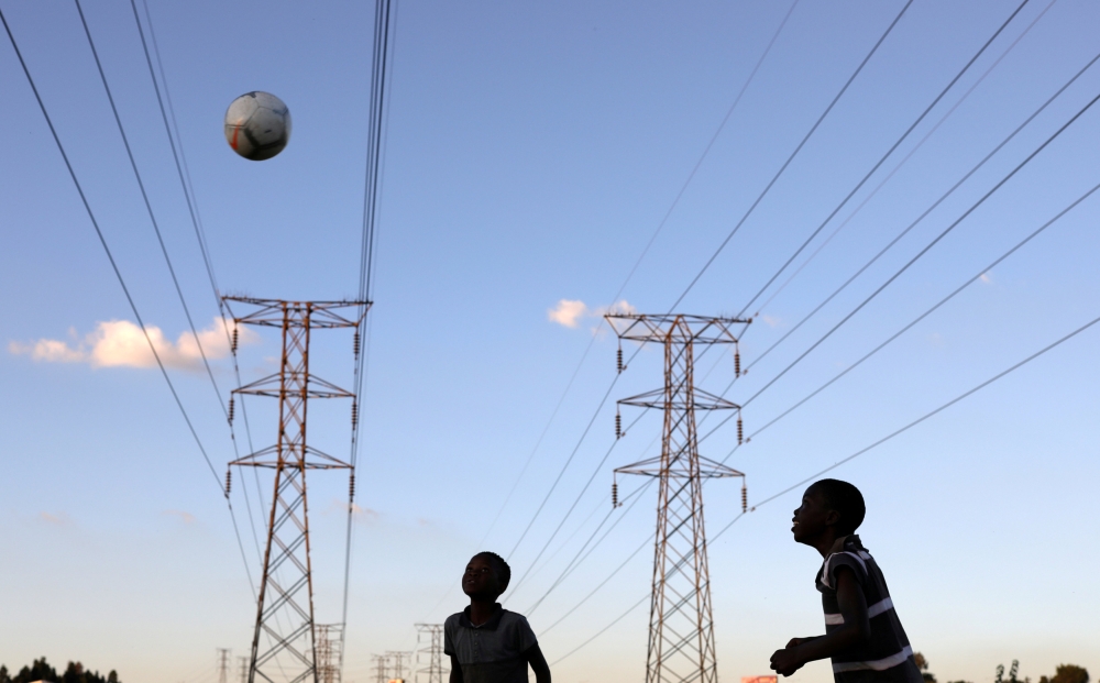 Boys play soccer below electricity pylons in Soweto, South Africa, in this Feb. 20, 2019 file photo. — Reuters