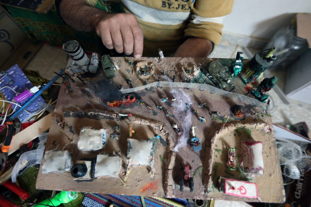 


Palestinian diorama artist Majdi Abu Taqeya works on miniature figures he carves from remnants of Israeli ammunition collected from the scenes of border protests along the Israel-Gaza border, in the central Gaza Strip. — Reuters photos