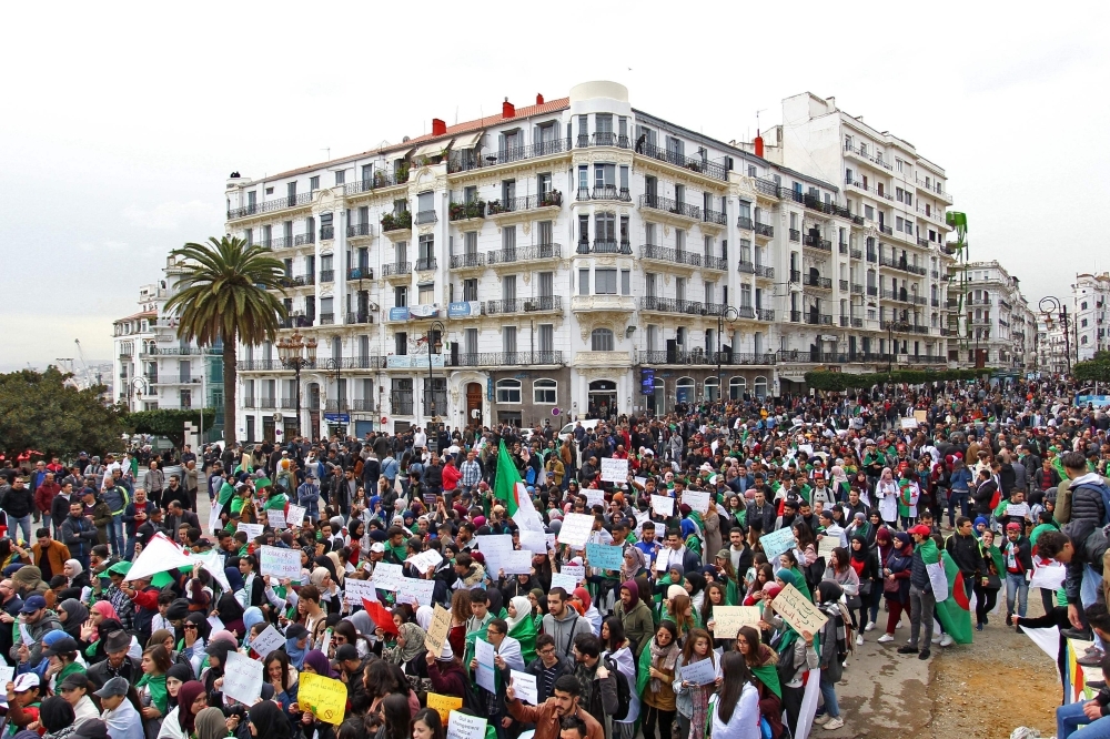 Algerians carry placards and national flags as they take part in a demonstration in the capital Algiers against President Abdelaziz Bouteflika on Tuesday. — AFP