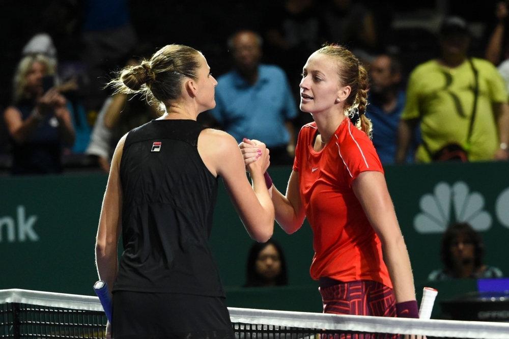 In this file photo tCzech Republic's Karolina Pliskova (L) shakes hands with her compatriot Petra Kvitova after winning their singles match at the WTA Finals tennis tournament in Singapore. Kvitova and Pliskova will snub the Fed Cup playoffs against Canada in April, raising the chances of holders the Czech Republic being relegated from the World Group, the Czech team said Thursday. — AFP