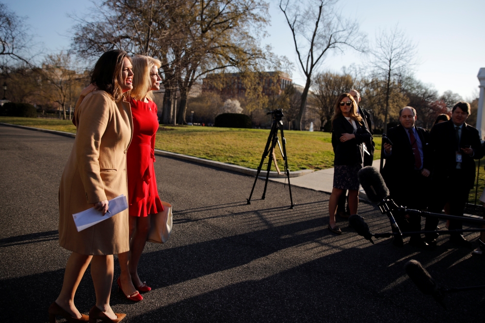 White House Press Secretary Sarah Sanders, right, and White House Counselor Kellyanne Conway react as they see each other at the White House in Washington on Monday. — Reuters