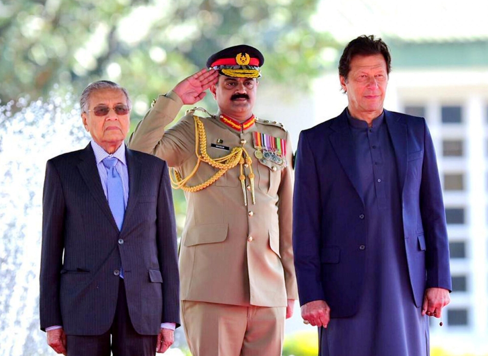 Malaysia Prime Minister Mahathir Mohamad, left, and Pakistani Prime Minister Imran Khan, right, stand during the national anthem at a ceremony in Islamabad, Pakistan, in this March 22, 2019 file photo. — Reuters