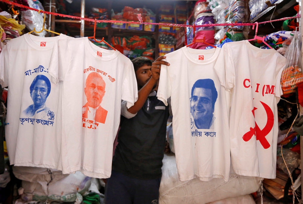 A worker displays T-shirts with images of, left to right, Chief Minister of West Bengal state Mamata Banerjee, Prime Minister Narendra Modi, India’s main opposition Congress party chief Rahul Gandhi and logo of Communist Party of India (Marxist) CPI (M), for sale inside a shop at a market ahead of India's general election, in Kolkata, India, on Tuesday. — Reuters