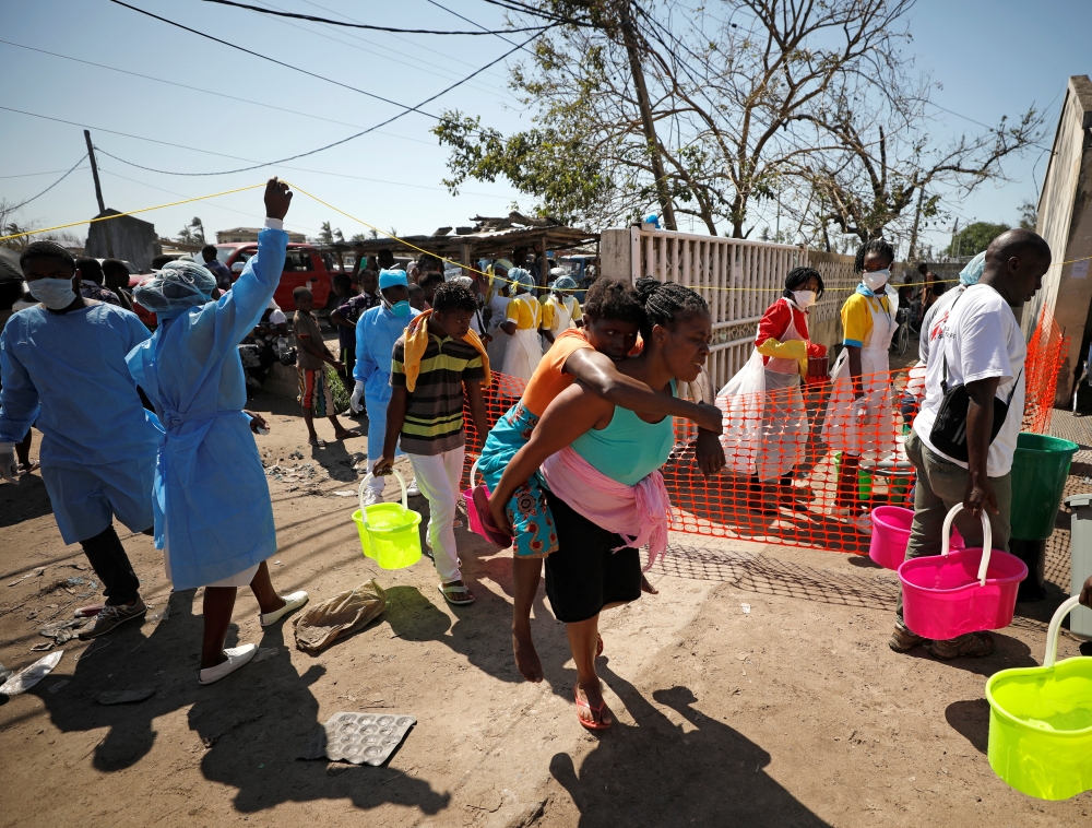 A woman is carried outside a health center in Beira, Mozambique, on Tuesday. — Reuters