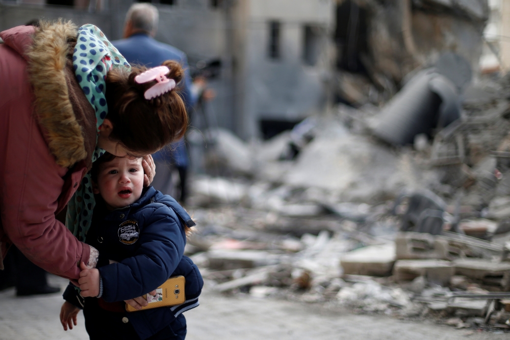 A Palestinian woman comforts her son outside their destroyed house after Israeli airstrikes targeted a nearby Hamas site in Gaza City, Monday.