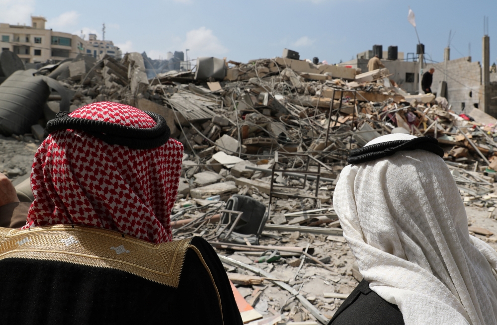 A Palestinian woman comforts her son outside their destroyed house after Israeli airstrikes targeted a nearby Hamas site in Gaza City, Monday.