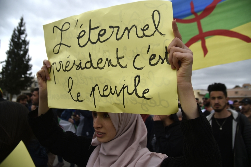 An Algerian woman raises a placard during a demonstration against President Abdelaziz Bouteflika in the city of Bejaia, some 220 km east of the capital Algiers. The placard reads in French: 