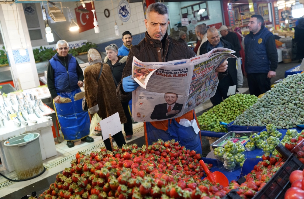 A stallholder reads a newspaper as he waits for customers at a bazaar in Ankara, Turkey, in this March 26, 2019 file photo. — Reuters