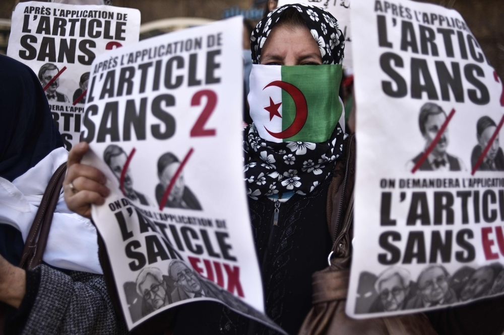 A protester holds placards during a demonstration against ailing President Abdelaziz Bouteflika in the capital Algiers on Friday. — AFP