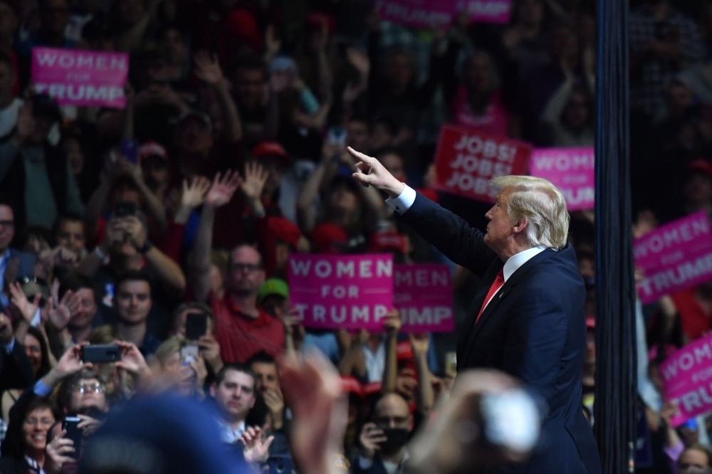 US President Donald Trump points to supporters during a campaign rally in Grand Rapids, Michigan, on Thursday. — AFP