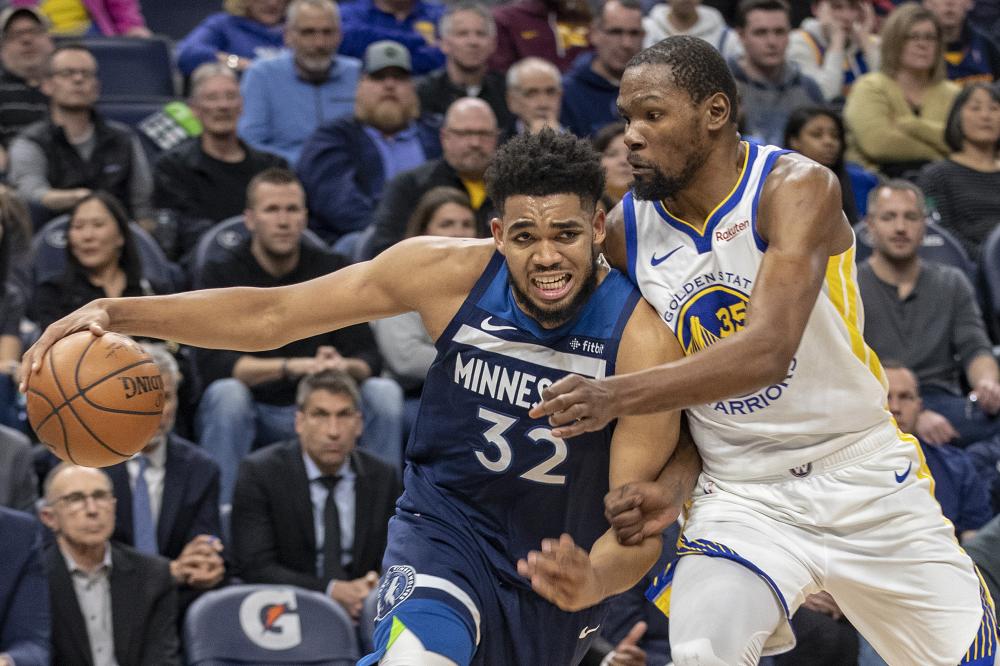 Minnesota Timberwolves’ center Karl-Anthony Towns drives to the basket past Golden State Warriors’ forward Kevin Durant during their NBA game at Target Center in Minneapolis Friday. — Reuters