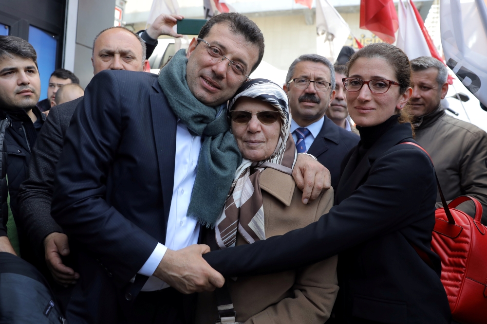 Ekrem Imamoglu, main opposition Republican People's Party (CHP) candidate for mayor of Istanbul, poses with his mother Hava Imamoglu and his sister in Istanbul, Monday. — Reuters