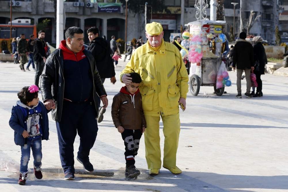 Abu Zakkour, Aleppo's so-called 'Yellow man' walks along with pedestrians in the central Saadallah Al-Jabiri Square in the northern Syrian city. Dressed in yellow from head-to-toe, Abu Zakkour is hailed as part of the 
