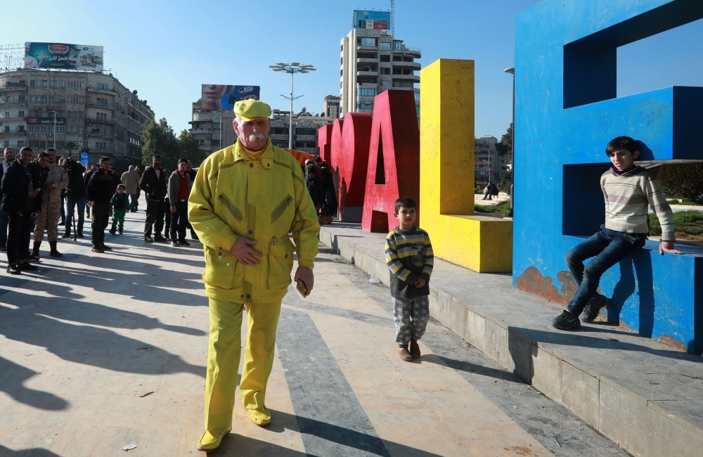 Abu Zakkour, Aleppo's so-called 'Yellow man' walks along with pedestrians in the central Saadallah Al-Jabiri Square in the northern Syrian city. Dressed in yellow from head-to-toe, Abu Zakkour is hailed as part of the 