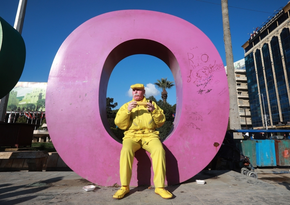 Abu Zakkour, Aleppo's so-called 'Yellow man' walks along with pedestrians in the central Saadallah Al-Jabiri Square in the northern Syrian city. Dressed in yellow from head-to-toe, Abu Zakkour is hailed as part of the 