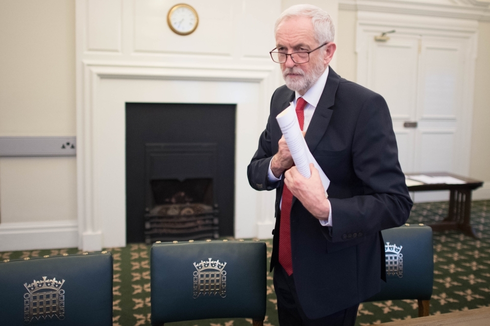 Britain’s main opposition Labour Party leader Jeremy Corbyn poses with a copy of the Political Declaration setting out the framework for the future UK-EU relationship, in his office in the Houses of Parliament in London on Tuesday. — AFP