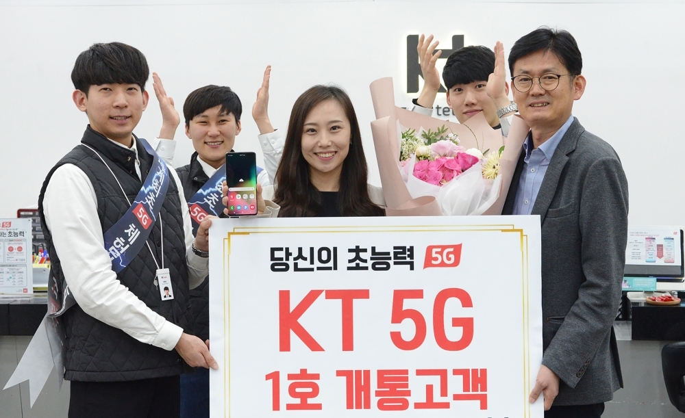 This picture shows KT staff posing with the company's first 5G smartphone subscriber Lee Ji-eun (C) during a 5G launching ceremony at a KT shop in Daegu. South Korea launched the world's first nationwide 5G mobile networks two days early, its top mobile carriers said on Thursday, in a late-night scramble to be the first providers of the super-fast wireless technology. — AFP