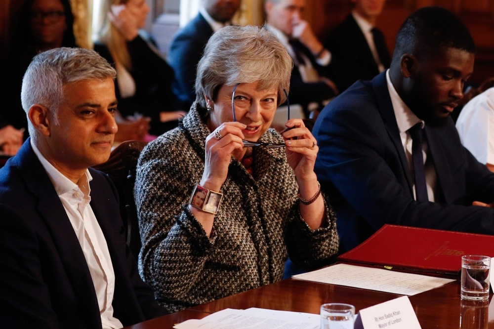 Britain’s Prime Minister Theresa May, center, hosts a Serious Youth Violence Summit flanked by London Mayor Sadiq Khan, left, and Youth Justice Board co-chair Roy Sefa-Attakora, right, at 10 Downing Street in central London in this April 1, 2019 file photo. — AFP