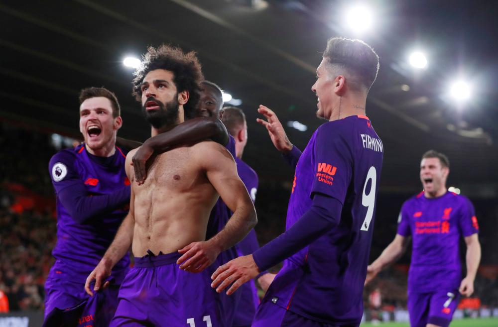 Liverpool’s Mohamed Salah celebrates scoring their second goal with teammates during their Premier League match against Southampton at St Mary’s Stadium, Southampton, Friday. — Reuters